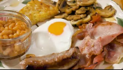 a plate of breakfast food with eggs bacon beans and mushrooms at Charming Guest House in Cornish Countryside in Bodmin