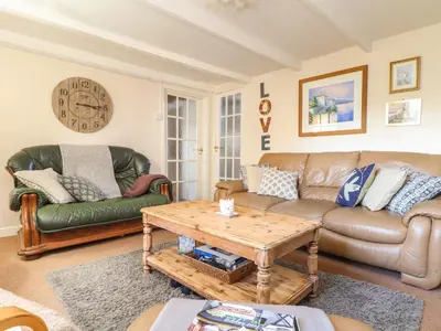 a living room with a couch and a table at The Nest in Helston