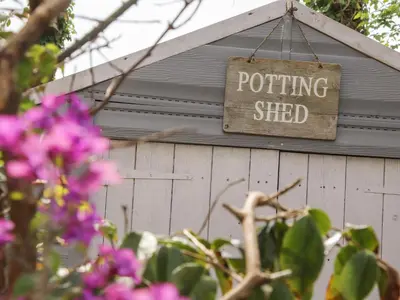 a sign that says potting shed hanging on a building at The Nest in Helston