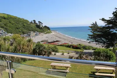 a view of a beach with two benches and the ocean at Beach View - Mount Brioni in Downderry