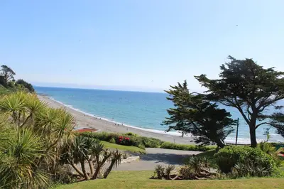 a beach with a tree and the ocean at Beach View - Mount Brioni in Downderry