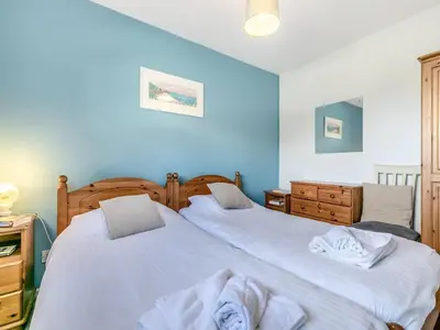 two beds in a bedroom with blue walls at View of the Sea - Mount Brioni in Downderry