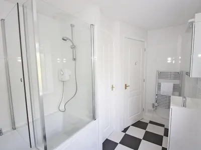 a bathroom with a shower with a glass door at Sandcastles - Mount Brioni in Downderry