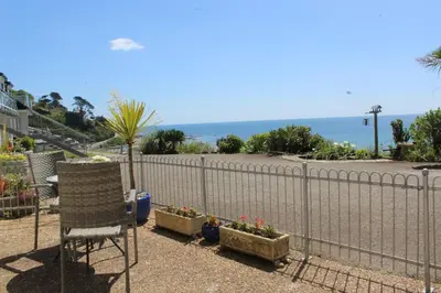 a chair and some plants and a fence at Sandcastles - Mount Brioni in Downderry