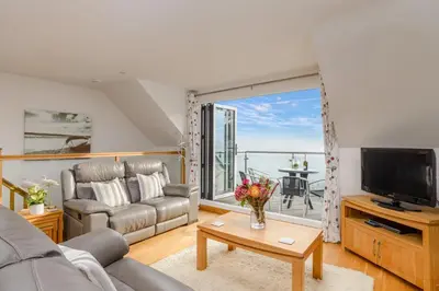 a living room with a couch and a television at Breakers - Mount Brioni in Downderry