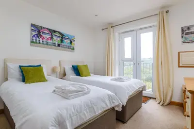 two beds in a room with a window at Breakers - Mount Brioni in Downderry