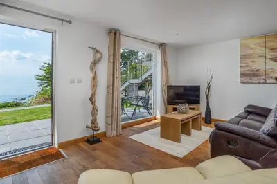 a living room with a couch and a view of the ocean at Beach Retreat - Mount Brioni in Downderry