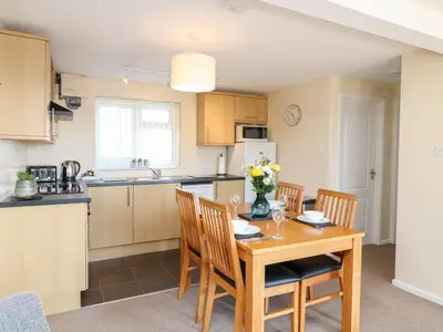 a kitchen and dining room with a wooden table and chairs at Apartment 2 - Mount Brioni in Downderry
