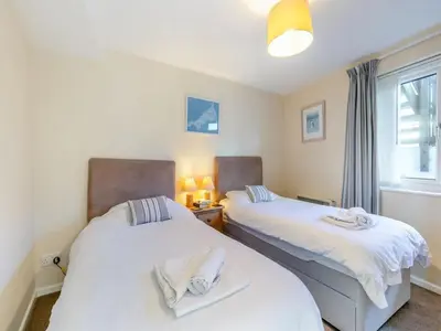 two twin beds in a room with a window at Apartment 2 - Mount Brioni in Downderry