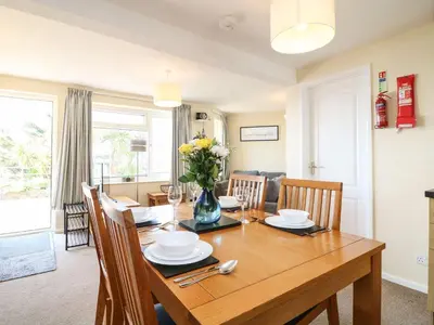 a dining room and living room with a wooden table and chairs at Apartment 2 - Mount Brioni in Downderry