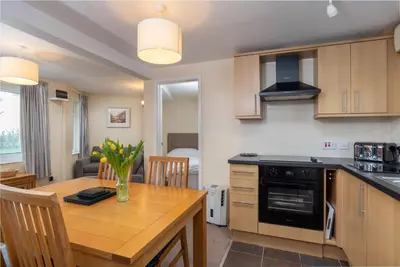 a kitchen with a wooden table and a dining room at Apartment 2 - Mount Brioni in Downderry