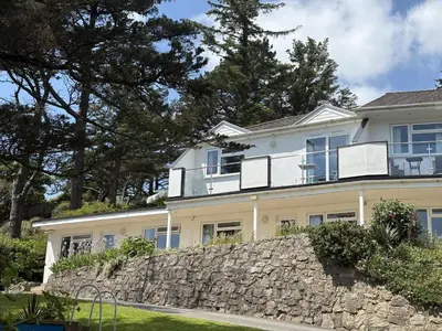 a large white house with a stone wall at Trevian - Mount Brioni in Downderry