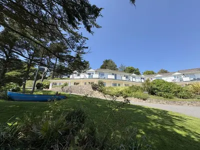 a house with a blue boat in the grass at Trevian - Mount Brioni in Downderry