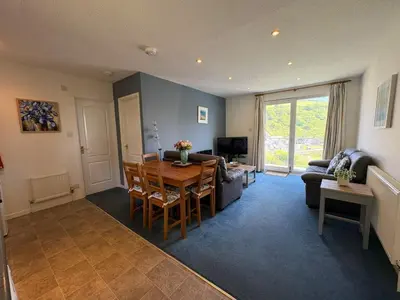 a living room with a table and a couch at Ocean Waves - Mount Brioni in Downderry