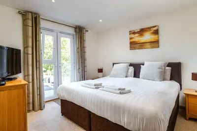 a bedroom with a large bed and a tv at Ocean View - Mount Brioni in Downderry