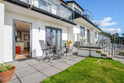 a patio with chairs and a table in front of a house at Ocean View - Mount Brioni in Downderry