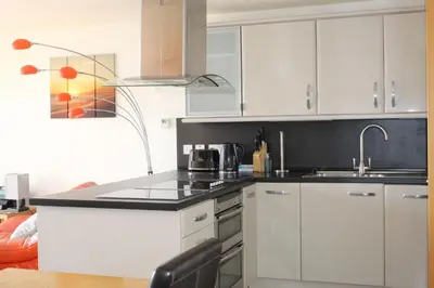 a kitchen with white cabinets and a sink at Ocean View - Mount Brioni in Downderry