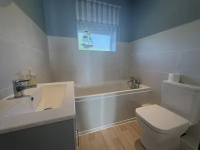 a bathroom with a sink and a toilet and a tub at Sea Gem - Mount Brioni in Downderry