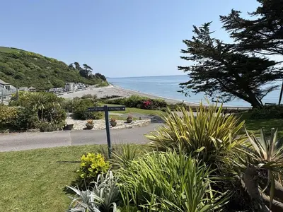 a street sign in the grass next to a beach at Sea Gem - Mount Brioni in Downderry
