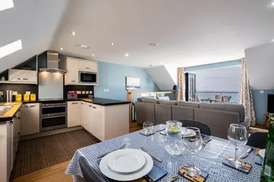 a kitchen and a living room with a table and a couch at Sea Gem - Mount Brioni in Downderry