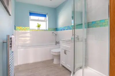 a bathroom with a tub and a toilet and a sink at The Lookout - Mount Brioni in Downderry