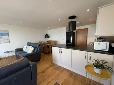 a kitchen and living room with a couch and a table at Mi Casa Su Casa - Mount Brioni in Downderry