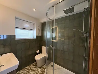 a bathroom with a toilet and a glass shower at Mi Casa Su Casa - Mount Brioni in Downderry