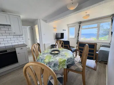 a kitchen and dining room with a table and chairs at Surf Watch - Mount Brioni in Downderry