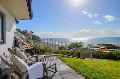 a patio with chairs and a view of the ocean at Eddystone View - Mount Brioni in Downderry