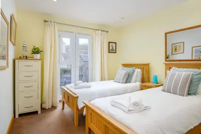 a bedroom with two beds and a window at Eddystone View - Mount Brioni in Downderry