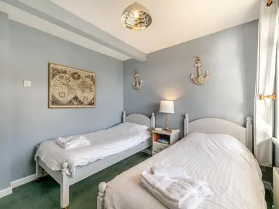 two twin beds in a room with blue walls at Cornish Riviera - Mount Brioni in Downderry