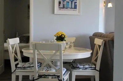 a white table and chairs with a vase of flowers on top at Salty Air - Mount Brioni in Downderry
