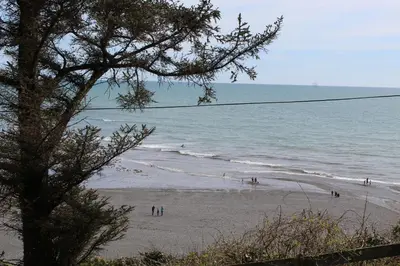 a group of people on a beach near the ocean at Salty Air - Mount Brioni in Downderry