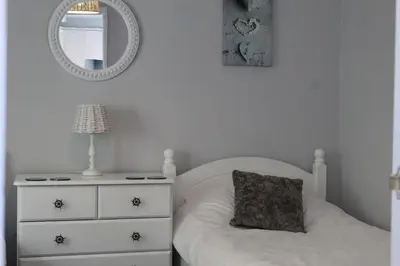 a bedroom with a bed with a dresser and a mirror at Salty Air - Mount Brioni in Downderry