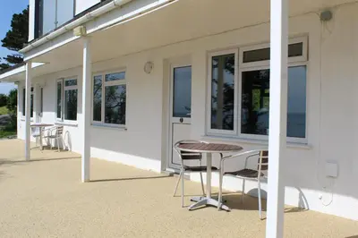 a table and chairs sitting outside of a building at Sand Bar - Mount Brioni in Downderry