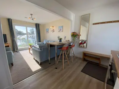 a living room with a table and chairs and a living room at Tide Watch - Mount Brioni in Downderry