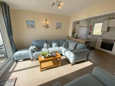 a living room with blue couches and a table at Tide Watch - Mount Brioni in Downderry