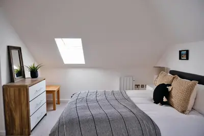 a bedroom with a bed with a black dog laying on it at Finest Retreats - Tolcarne Stay - Luxury Newquay Apartment in Newquay