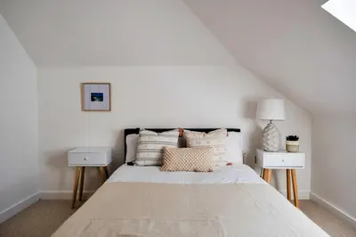a white bedroom with a bed with two night stands at Finest Retreats - Tolcarne Stay - Luxury Newquay Apartment in Newquay