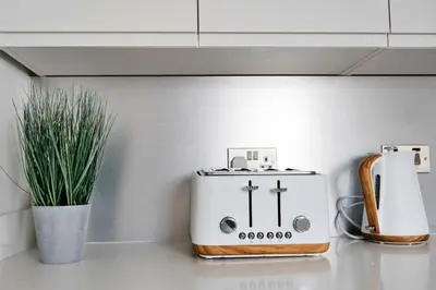 a toaster sitting on a kitchen counter next to a plant at Finest Retreats - Tolcarne Stay - Luxury Newquay Apartment in Newquay