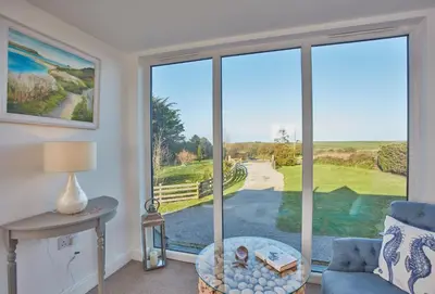 a living room with a large window with a view at Treveth Lowen in Saint Minver