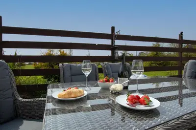 a table with plates of food and glasses of wine at Treveth Lowen in Saint Minver