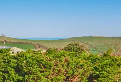 a view from the top of a hill with trees at Treveth Lowen in Saint Minver