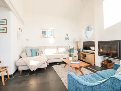 a living room with a couch and a tv at Jonwyns in Tintagel