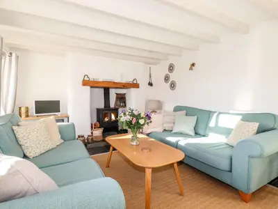 a living room with two blue couches and a table at Jonwyns in Tintagel
