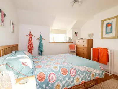 a bedroom with a bed with a blue comforter at Jonwyns in Tintagel