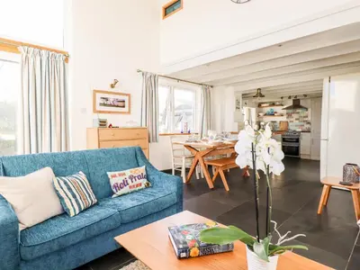 a living room with a blue couch and a table at Jonwyns in Tintagel