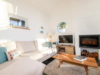 a living room with a white couch and a tv at Jonwyns in Tintagel