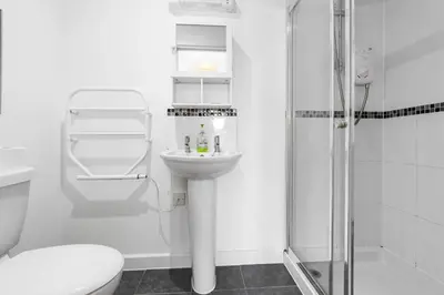a bathroom with a toilet and a sink and a shower at Coppercroft Cottage - Stunning Coastal Home, Walk to Beach, Sleeps 4 in Porthtowan