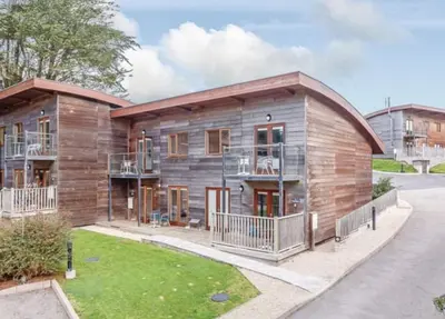 a large wooden building with a balcony at Coppercroft Cottage - Stunning Coastal Home, Walk to Beach, Sleeps 4 in Porthtowan